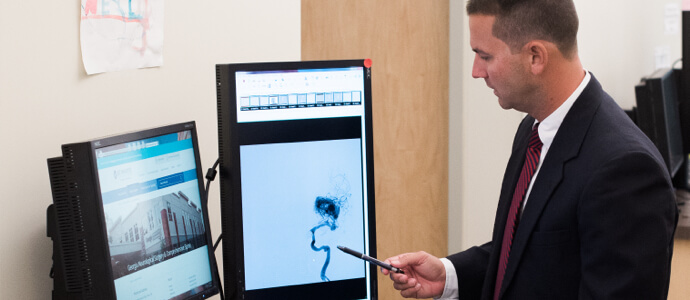 Dr. Woodall examines scan of a spine on a computer